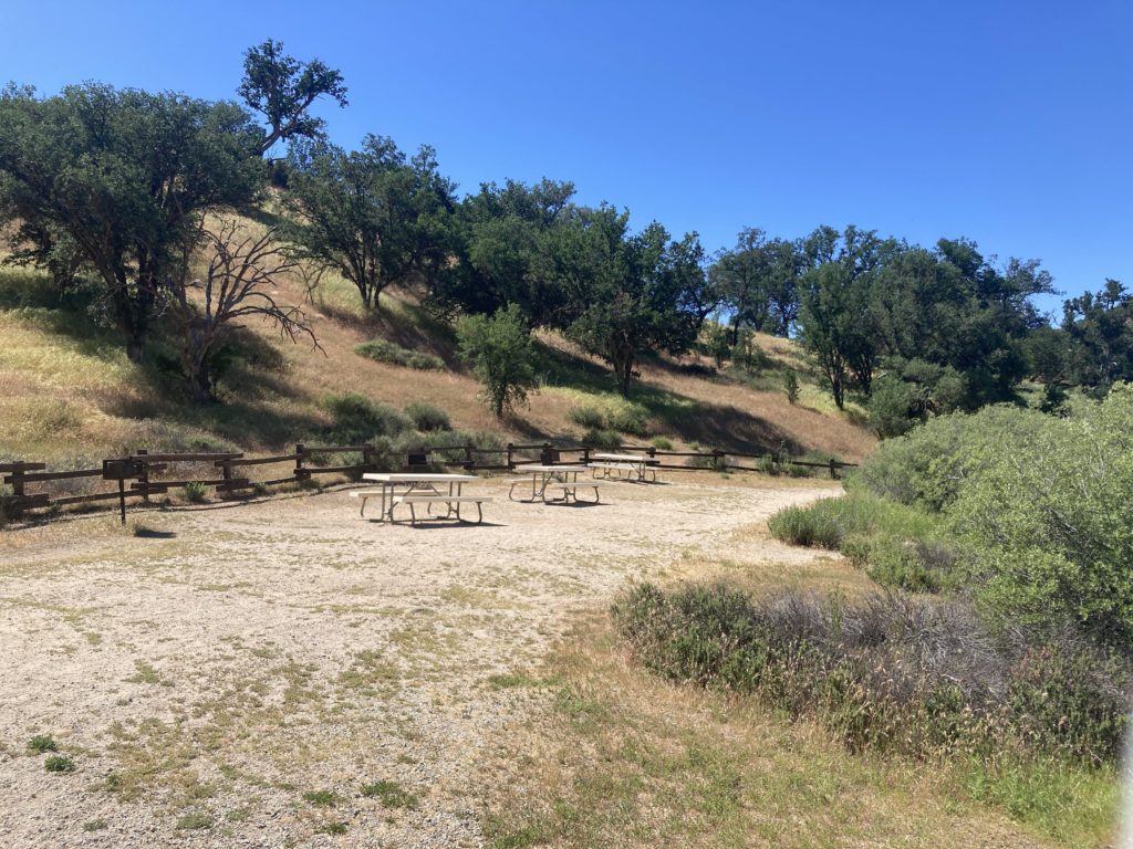 Tables and Chairs near the Hillside with Trees