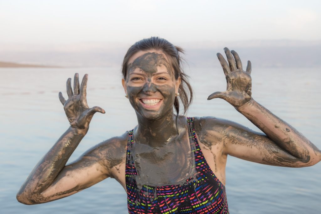 A woman covered in mud from the Dead Sea